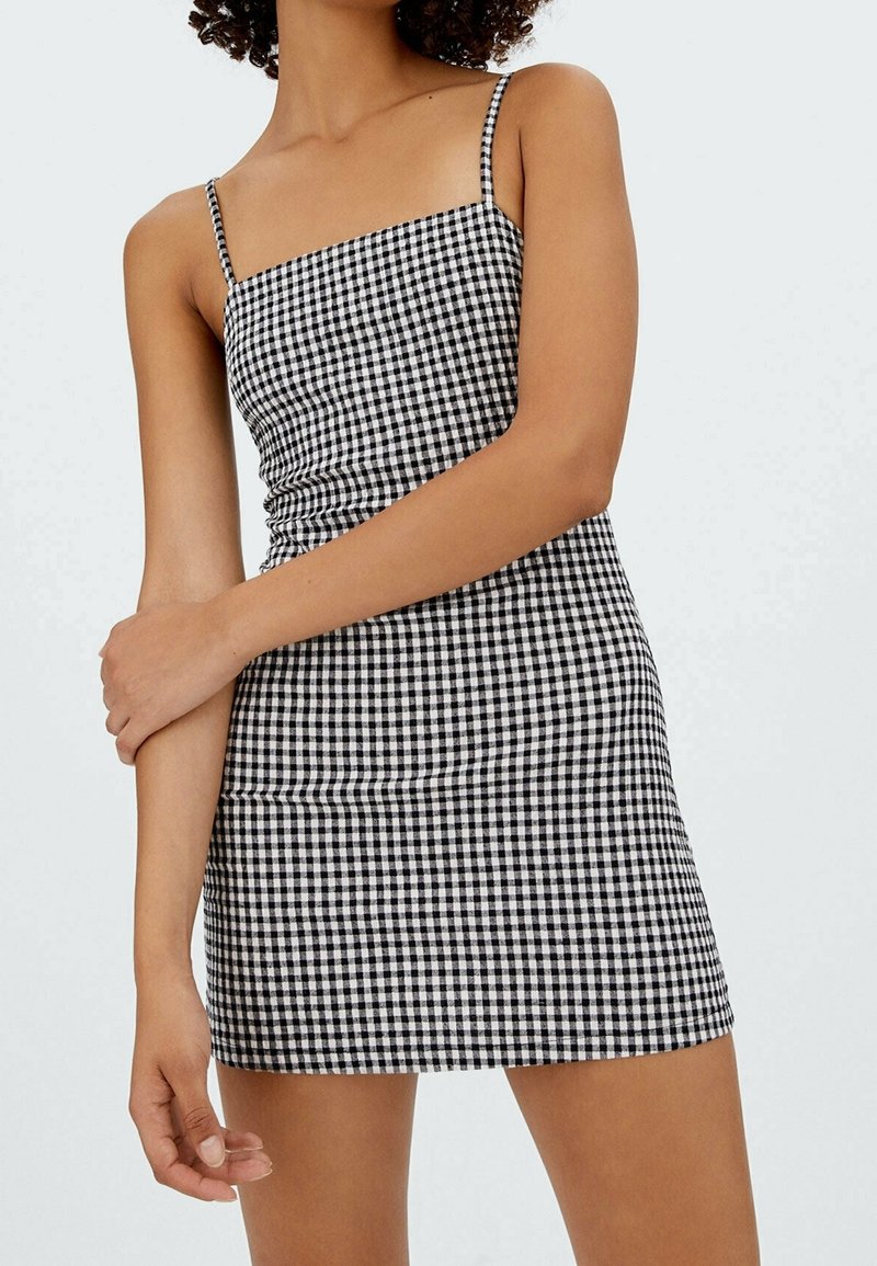 Sort og hvidt gingham mini-kjole med tynde stropper, tætsiddende liv og lige kant. Materiale i bomuldsblanding med en glat tekstur.