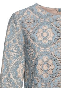 Spetsöverdel med blommönster i ljusblå tråd mot en beige bas, rund halsringning och långa ärmar.