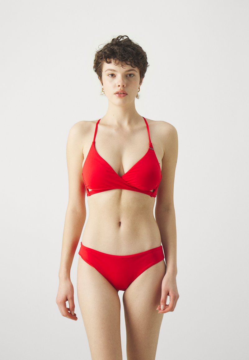 Ensemble de bikini rouge comprenant un haut style wrap avec des bretelles ajustables et un bas taille basse, fabriqué en tissu lisse et extensible.