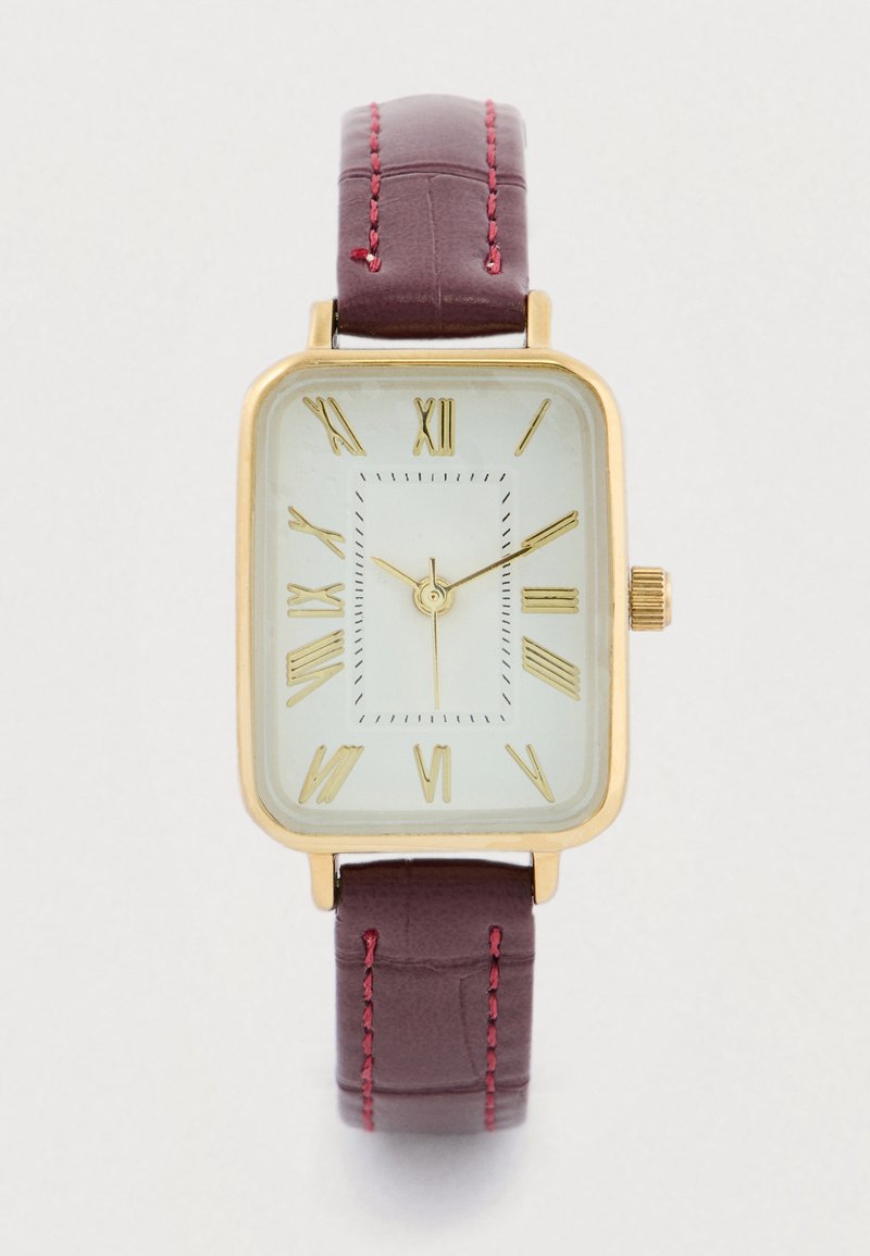 Relógio retangular dourado com marcadores de numerais romanos, apresentando um mostrador verde claro. Pulseira de couro vinho escuro com detalhes em vermelho na costura.