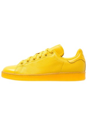 Gula sneakers i slätt läder och perforerad textur, med rund tå, låg profil och matchande gula snören.