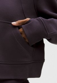 Dunkellila Kapuzenpullover mit weicher Textur, ausgestattet mit einer Fronttasche und gerippten Bündchen. Das Design zeichnet sich durch eine legere Passform und minimale Nähte aus.