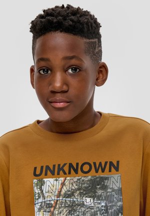 Brauner Sweatshirt aus strukturiertem Stoff, mit einem großen grafischen Design mit dem Wort "UNKNOWN" in fetten schwarzen Buchstaben auf der Vorderseite.