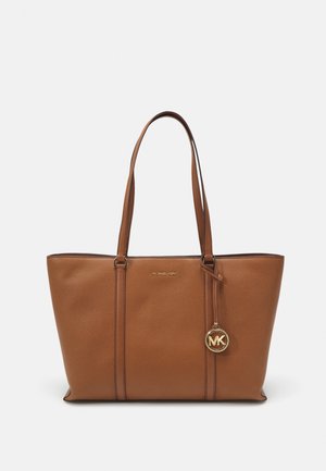 Brązowa skórzana torba na ramię z podwójnymi paskami na ramiona, złote logo Michael Kors oraz okrąły złoty charms MK wiszący z przodu.