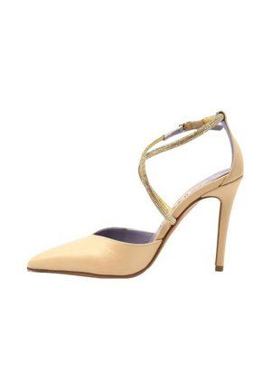 Scarpa con tacco alto beige, punta affusolata, materiale in pelle liscia e una cinghia decorativa alla caviglia con strass.