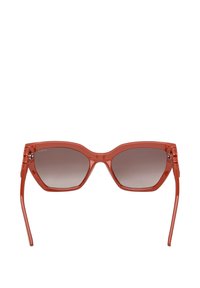Czerwone plastikowe okulary przeciwsłoneczne z gradientowymi soczewkami, kanciaste w kształcie kociego oka, z detalicznymi zdobieniami na zausznikach. Gładkie wykończenie z połyskującą teksturą.
