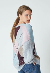 Maglione colorato in maglia con un motivo geometrico nelle tonalità di grigio, rosa, blu e marrone; vestibilità morbida con polsini e orlo a coste.