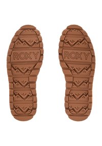 Bruine rubberen zoolen van schoenen met gestructureerde grip en een golfpatroon; met prominent het ingedrukte merk "ROXY" in het midden.