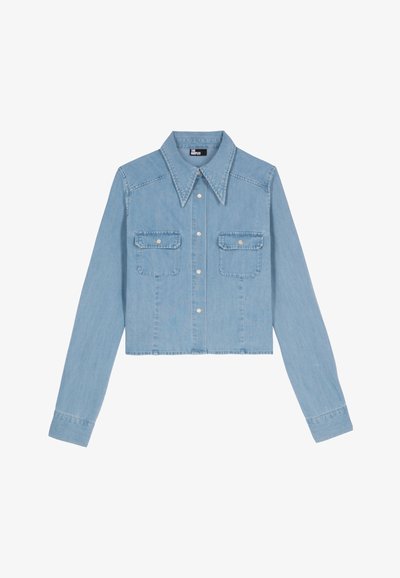 Camicia di denim tagliata in blu chiaro con maniche lunghe, colletto a punta, due tasche sul petto e chiusure con bottoni argentati. Texture liscia.