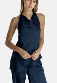 Navyblauwe satijnen haltertop met een gladde textuur, hoge halslijn en vloeiende ontwerp, gedragen met bijpassende satijnen broek.