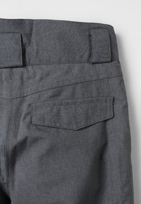 Graue Stoffhosen mit flachem Bund, subtiler Textur und Gesäßtaschen mit schrägen Klappen.