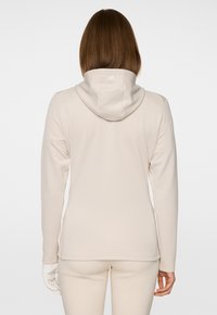 Felpa beige chiaro con una texture liscia, maniche lunghe e cappuccio con coulisse. Presenta un piccolo logo sul retro.