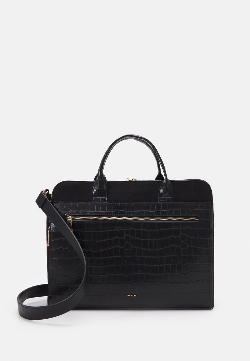 Mallette en cuir noir texturé avec poignées supérieures, poche avant zippée et bandoulière réglable sur fond blanc.