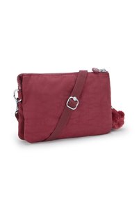 Borsa a tracolla borgogna con finitura testurizzata, tracolla regolabile, chiusura con zip e un'accattivante decorazione a pompon sul lato.
