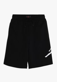 Svarta shorts i mjukt material, med elastisk midja och dragsko, samt en vit grafik av en hoppande figur på sidan.