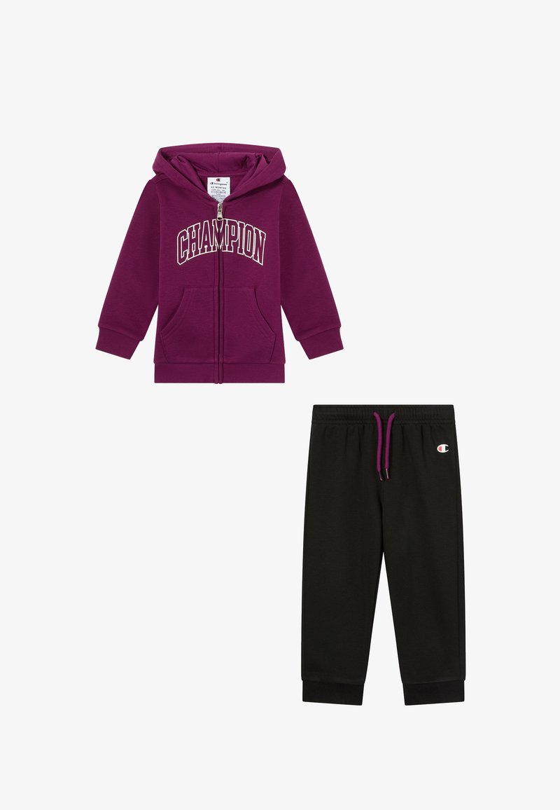 Felpa con cappuccio viola con testo "CHAMPION" e tasche anteriori; abbinata a pantaloni della tuta neri con vita elastica e dettaglio logo.