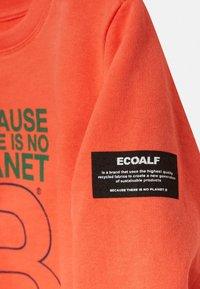 Orange sweatshirt med grön text som säger "EFTERSOM DET INTE FINNS NÅGON PLAN B." Har en svart Ecoalf-märke på ärmen med vit text.