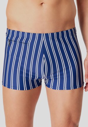 Modré plavkové kraťasy se svislými bílými pruhy, slim fit střihem a malou kapsou na zip na zadní straně. Hladká textilie.