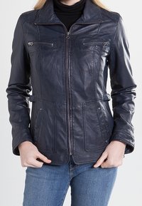 Mörkblå läderjacka med dragkedja framtill, två bröstfickor och två framfickor. Har en krage och figurskuren design.