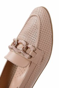 Mocassino in pelle perforata rosa chiaro con suola piatta, caratterizzato da un prominente dettaglio a catena sul davanti e una texture liscia.