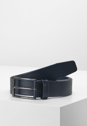 Marineblauwe leren riem met een getextureerd vierkant patroon en een zilverkleurige rechthoekige gesp gegraveerd met "Hugo Boss" op een witte ondergrond.