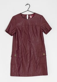 Burgundské kožené šaty s krátkým rukávem, kulatým výstřihem a dvěma předními kapsami se zlatými knoflíky. Mírně pokrčená textura.