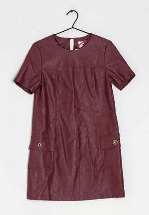 Bordeaux læderkjole med korte ærmer, rund halsudskæring og to forlommer med guldknapdetaljer. Let rynket tekstur.