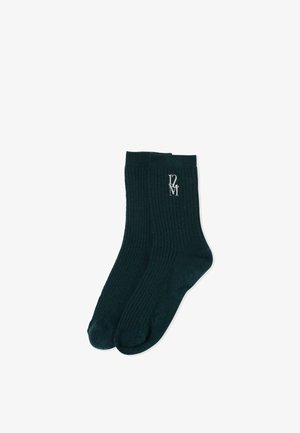 Paire de chaussettes montantes noires côtelées avec logo brodé blanc "D2M" près du haut du bord sur une chaussette.