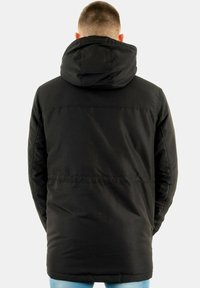 Giacca nera con cappuccio, dalla finitura liscia, design di media lunghezza e dettagli di cucitura minimi, con zip nascosta sulla schiena.