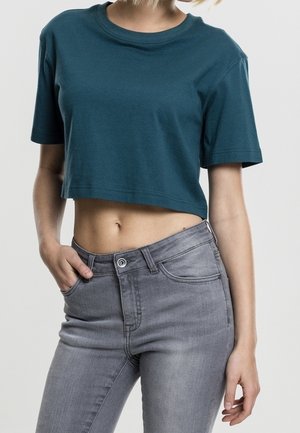 Turquoise cropped t-shirt met korte mouwen, gemaakt van zacht katoen. Gecombineerd met lichtgrijze, hooggetailleerde jeans met een voorkant met knoopsluiting.