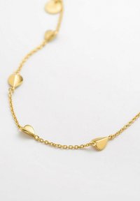 Guldhalsband med kedja som har tårformade hängsmycken och cirkulära detaljer, slät yta och en delikat design.