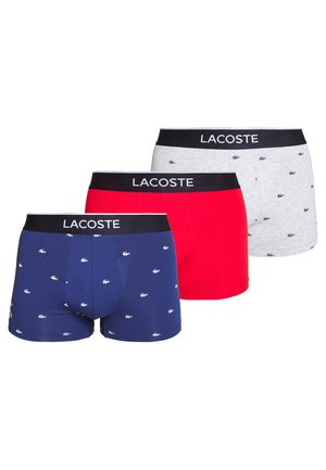 Três pares de boxers para homem em azul marinho, vermelho e cinza, com pequenos padrões do logótipo da Lacoste, apresentando cinturas elásticas pretas rotuladas "LACOSTE."