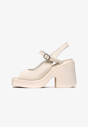 Sandali platform beige con punta aperta e design slingback. Presentano un tacco largo e spesso e una cinturino regolabile con fibbia. Texture liscia.
