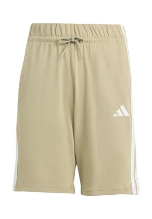 Twee kinderen staan rug aan rug, gekleed in bijpassende beige Adidas shorts en T-shirts met witte strepen, witte sokken en zwart-witte sneakers.