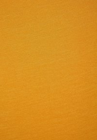 Teksturowana, elastyczna tkanina w jednolitym kolorze musztardowym. Gładka powierzchnia z subtelnymi wariacjami w odcieniu. Odpowiednia do zastosowań odzieżowych.