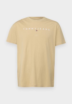 Bež pamučna majica kratkih rukava s okruglim izrezom, s natpisom "TOMMYJEANS" i malim logotipom. Glatka tekstura.