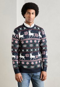 Sweater de malha azul-marinho com um padrão de rena e flocos de neve em branco, vermelho e verde. Gola redonda e punhos canelados.