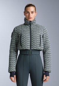 Tkani pufast jakna u plavoj i bijeloj boji, s visokim ovratnikom, dva džepa sa zipom i strukom koja se stegne remenom.