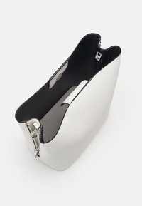 Witte leren tote bag met een zwarte binnenkant, open bovenkant en ritsluiting. Beschikt over een accent van zilverkleurig hardware en een binnenvak.