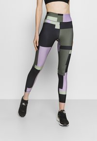 Legginsy wysokiej talii w geometryczny wzór z czarnymi, zielonymi i fioletowymi kolorami. Wykonane z elastycznego, gładkiego materiału.