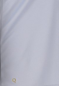 Lysblå sportsshorts lavet af glat, åndbart stof. Har et lille guld "Q" logo nær den nederste kant.