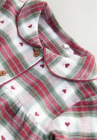 Rot-grün karierter Hemd mit Plaid-Muster, weißem Hintergrund, gestickten Herzen und einem runden Kragen mit Knopfverschluss.