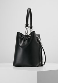 Sort læderbucket-taske med sølvhardware, justerbar rem og snørelukning. Glat tekstur med en struktureret form.