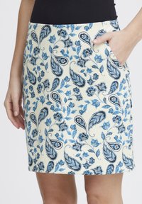 Fustă din țesătură crem cu imprimeu floral și paisley albastru. Prezentă o buzunar lateral și un tiv dreapt, oferind o siluetă ajustată.