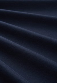 Mørkeblå stof med glat tekstur, der viser flere bløde folder og et ensartet udseende. Ingen mønstre eller hardware synlige.