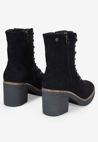 Stivaletti neri in suede con tacco a blocco testurizzato, lacci frontalmente, cerniera laterale e cuciture decorative lungo il bordo della suola.