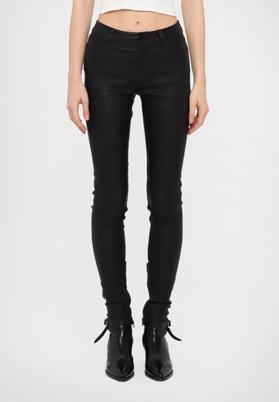 Pantalons skinny en simili cuir noir avec une taille haute, fermeture éclair à l'avant et zips aux chevilles. Texture lisse avec un design ajusté.