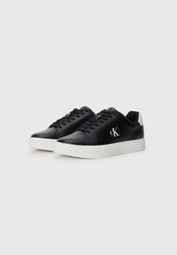 Zwarte leren sneakers met een witte zool en veters. Beschikt over een subtiele logo aan de zijkant en een contrasterend materiaal op de hiel.