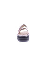 Pink slide sandal with two straps, soft upper material, natural footbed, and a thick black outsole featuring a scalloped edge.