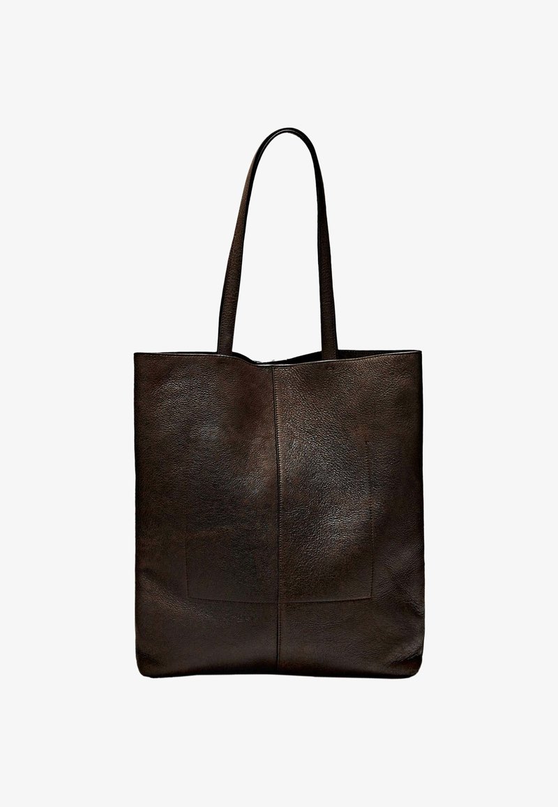 Brown leather tote bag with a simple rectangular shape, featuring two long handles and two front patch pockets. Smooth texture.